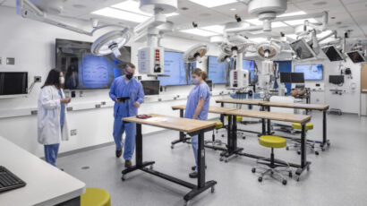 People assemble around an active learning tables in the Mayo Clinic simulation center.